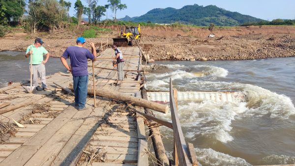 Voluntários iniciam reconstrução da ponte de contêineres