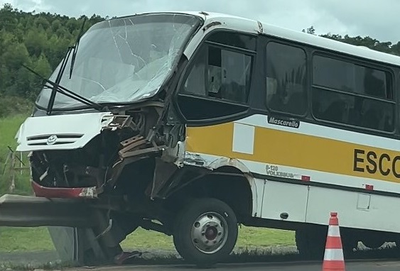 Micro-ônibus escolar bate com carreta e para sobre guarda-corpo na BR-386